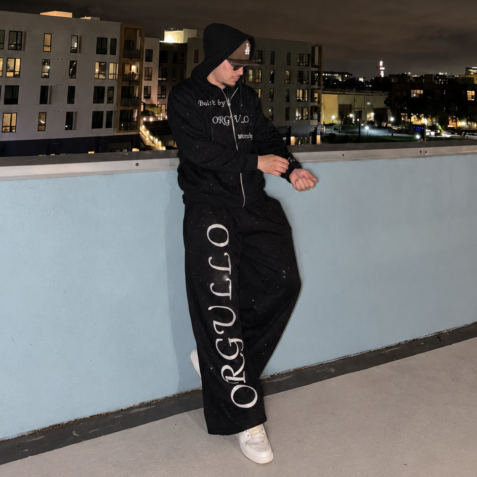 Model wearing black Built by ORGULLO rhinestone zip-up hoodie and matching sweatpants