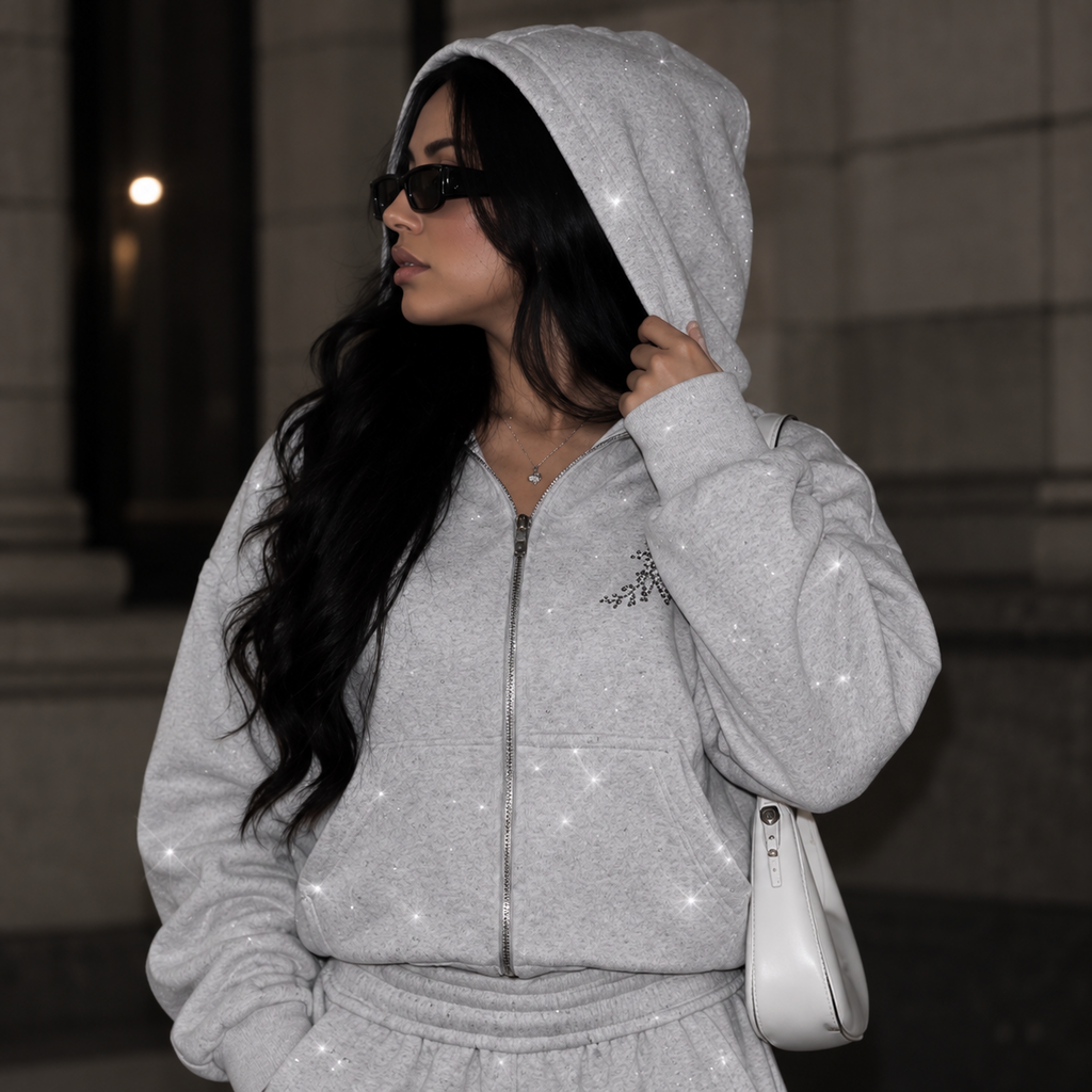 Close-up of model wearing M&N Orgullo gray rhinestone zip-up hoodie
