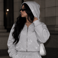 Close-up of model wearing M&N Orgullo gray rhinestone zip-up hoodie