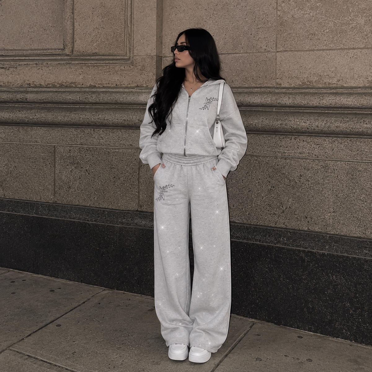 Model wearing M&N Orgullo gray rhinestone zip-up hoodie and matching sweatpants
