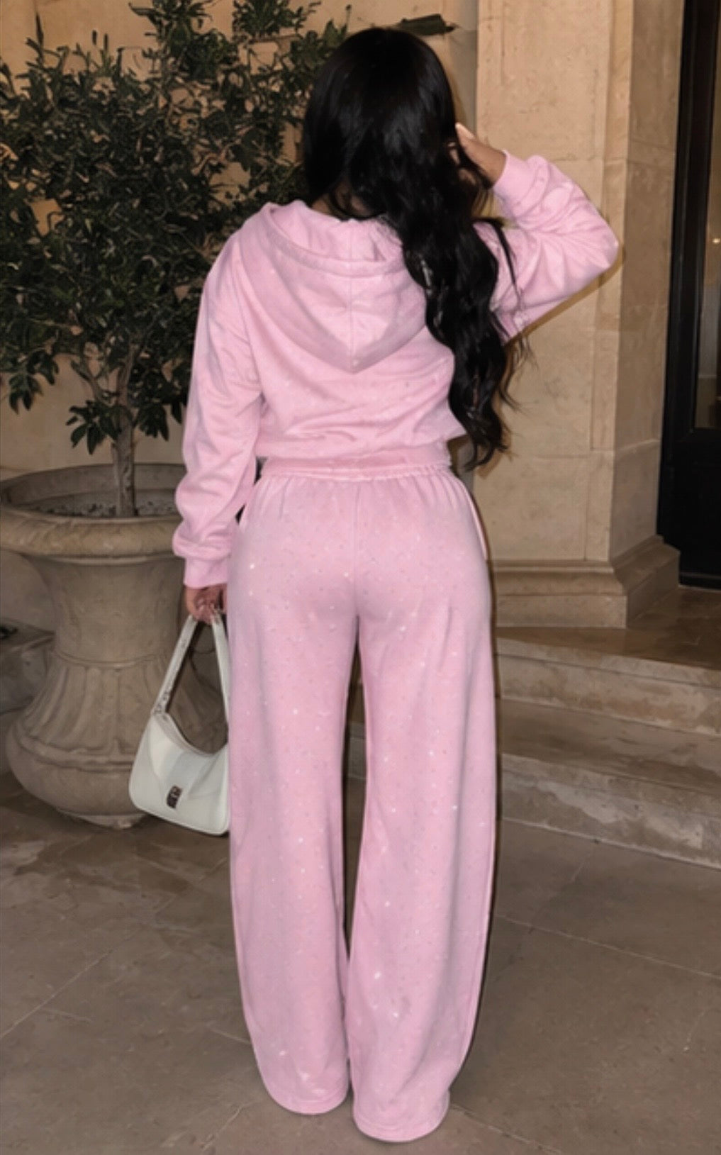 Model wearing M&N Orgullo pink rhinestone sweatpants and matching hoodie